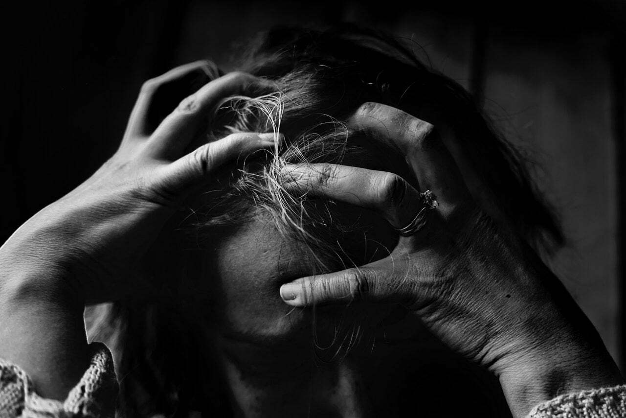 a black and white photo of a person with the hands in the mouth