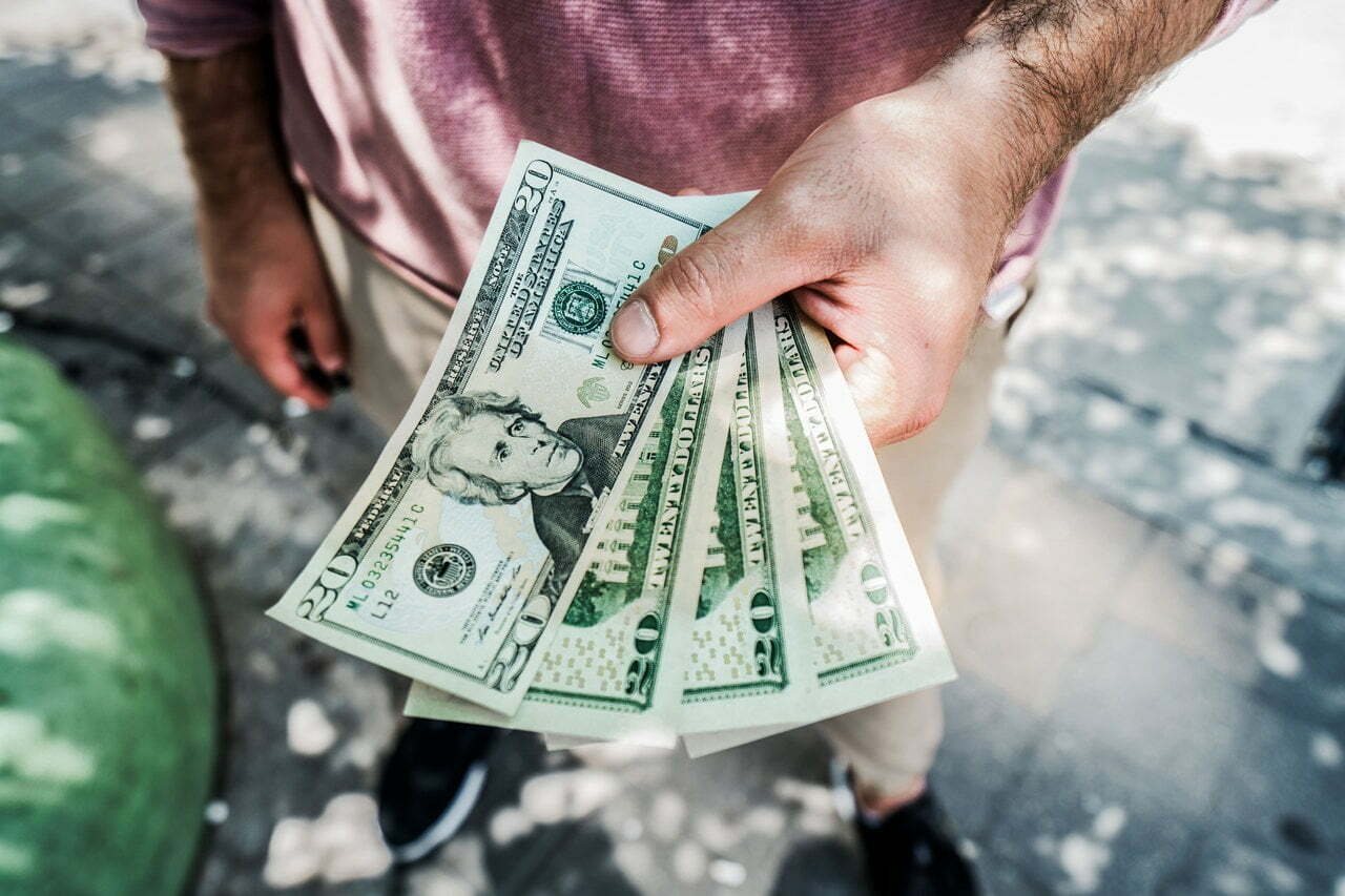 a man holding a fanned out dollar bills