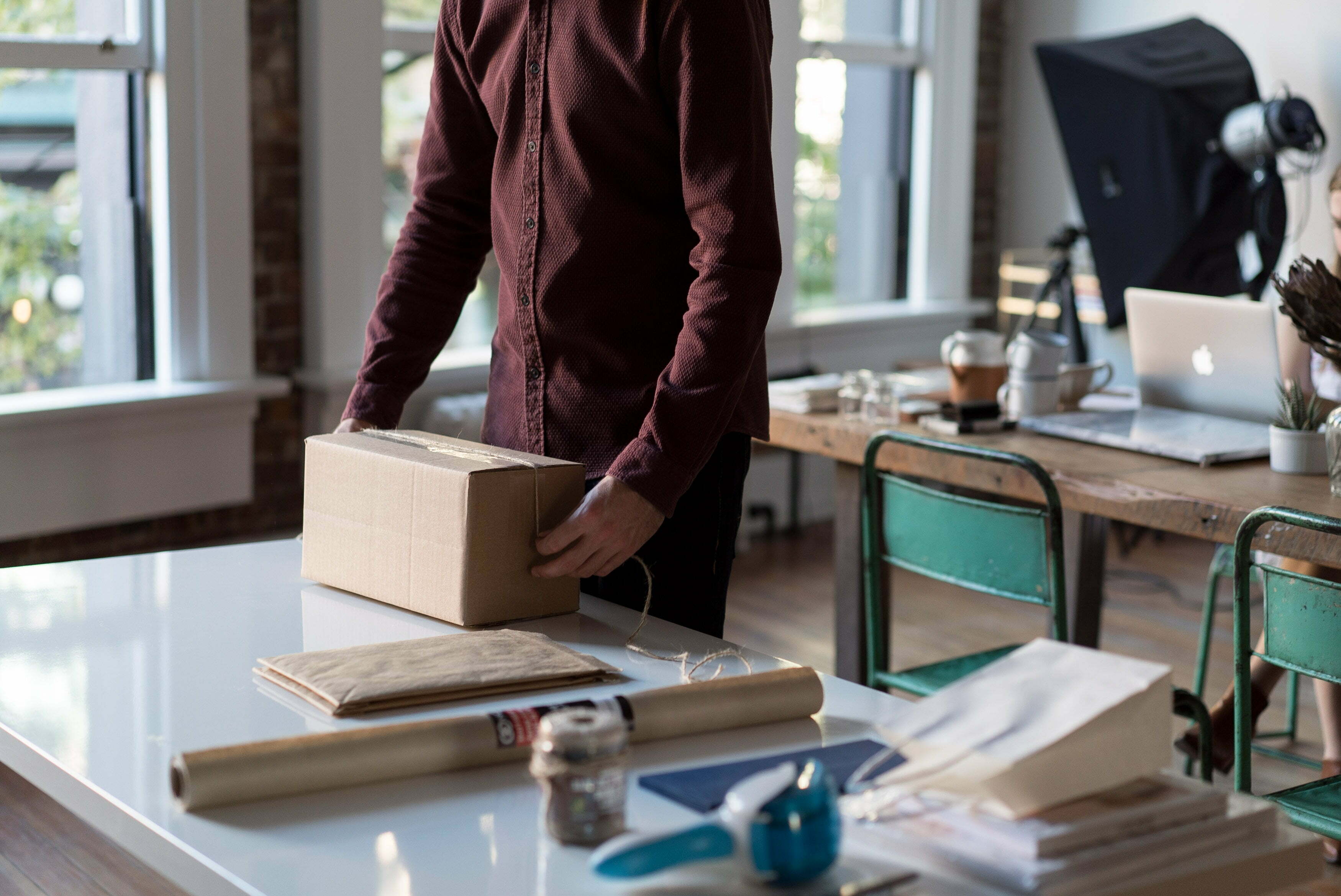 a person standing in a room with a desk and a laptop