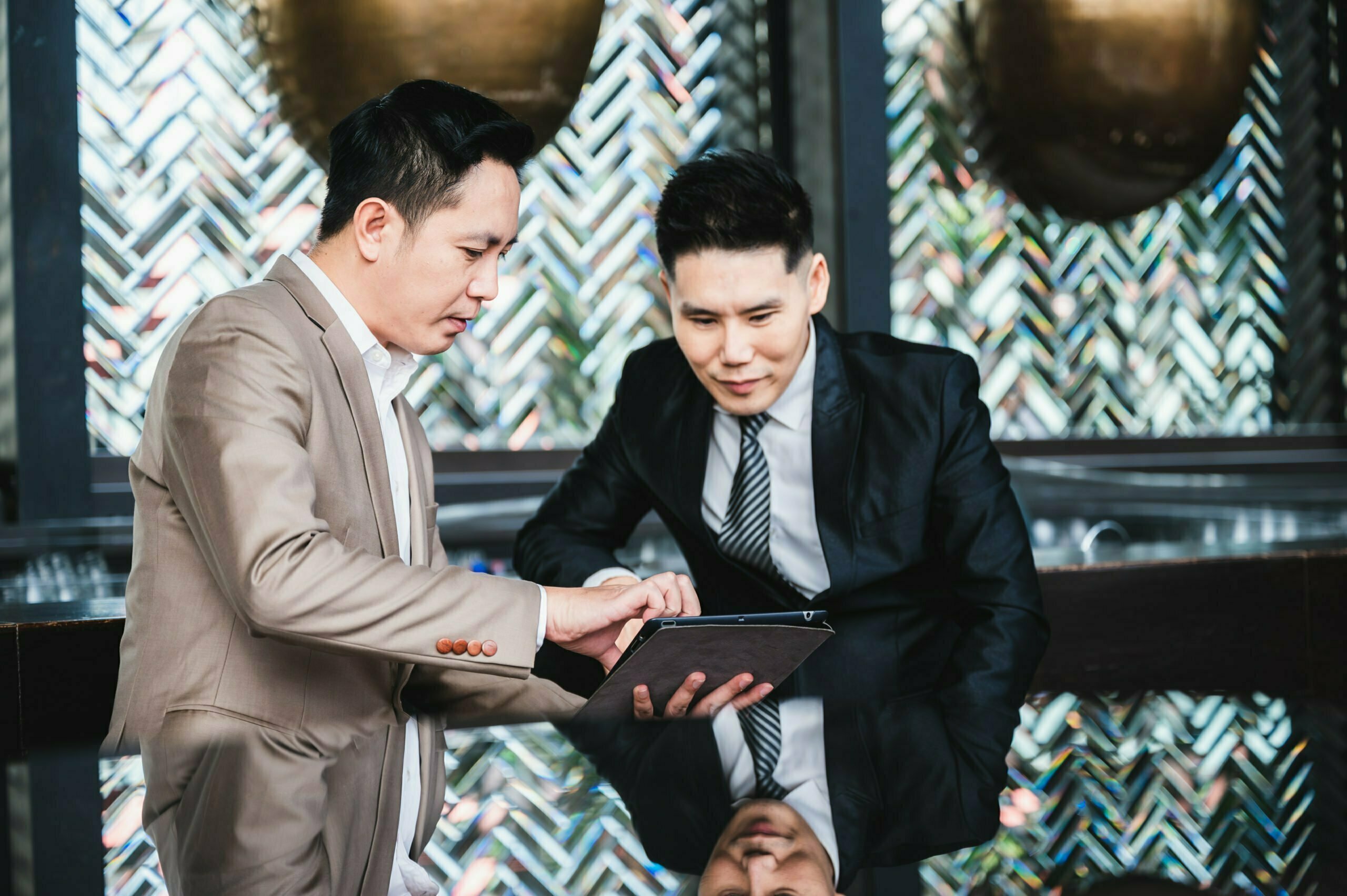 a man and a woman looking at a tablet