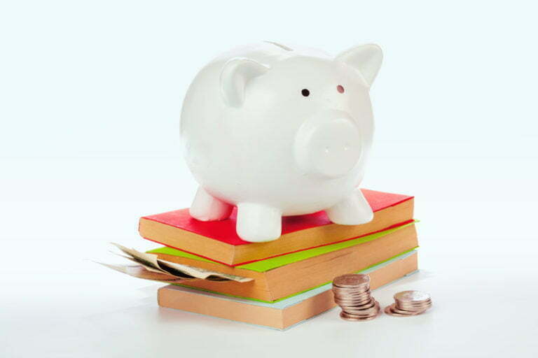 a white stuffed pig on a pile of books