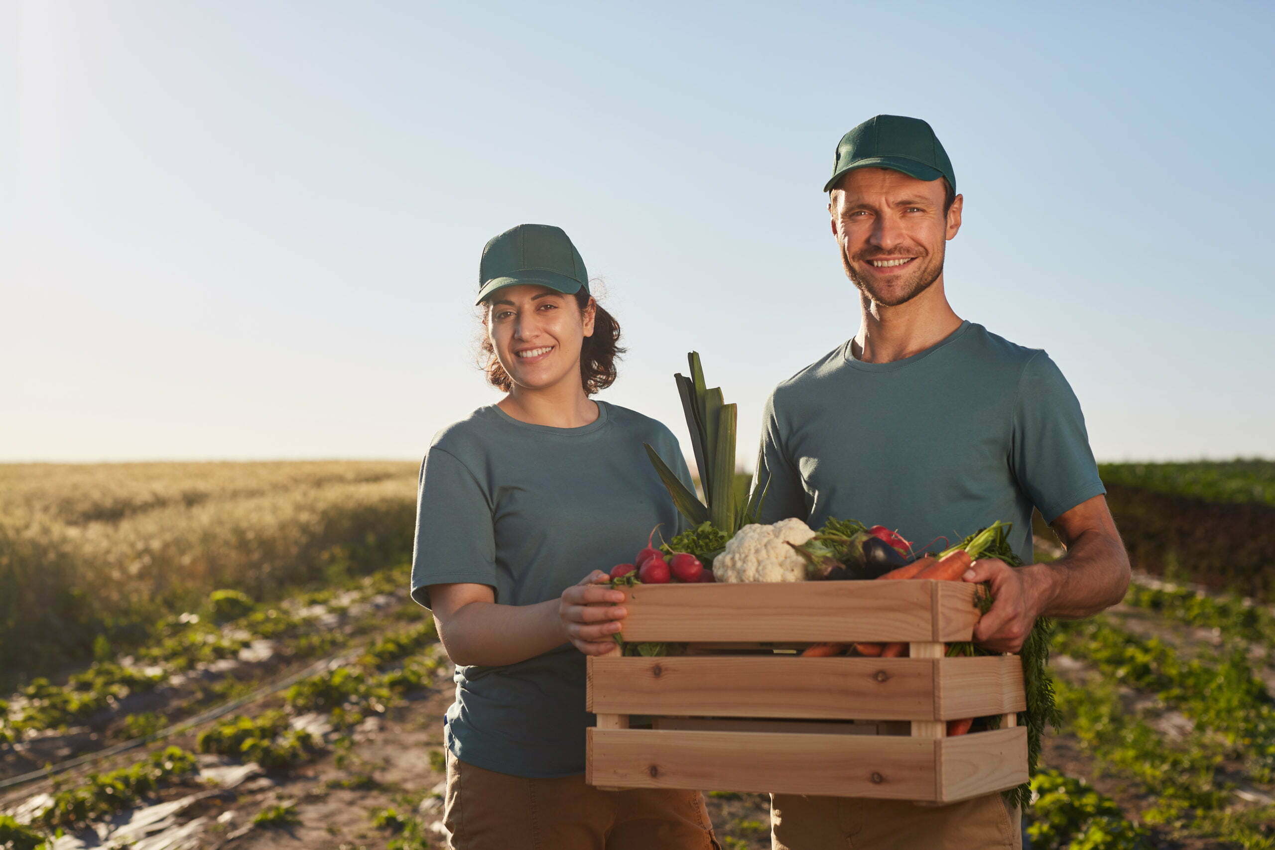 a man and woman holding a basket of vegetables